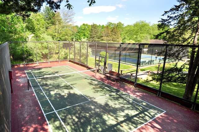 view of tennis court featuring fence