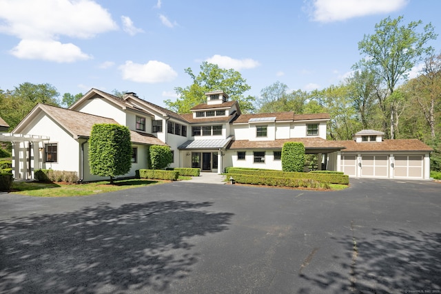 1580 Ponus Rdg, New Canaan, CT 06840 - view of front of property with asphalt driveway, a garage, and stucco siding