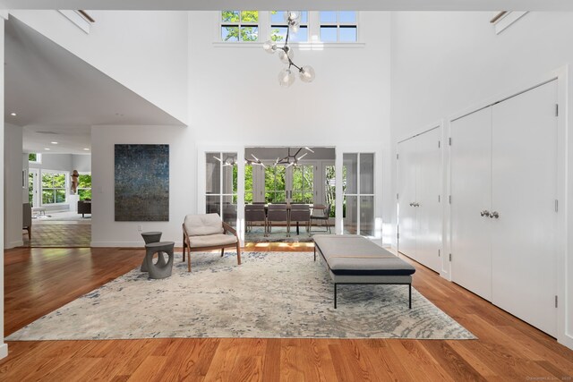 1580 Ponus Rdg, New Canaan, CT 06840 - living room featuring a towering ceiling, wood finished floors, and a chandelier