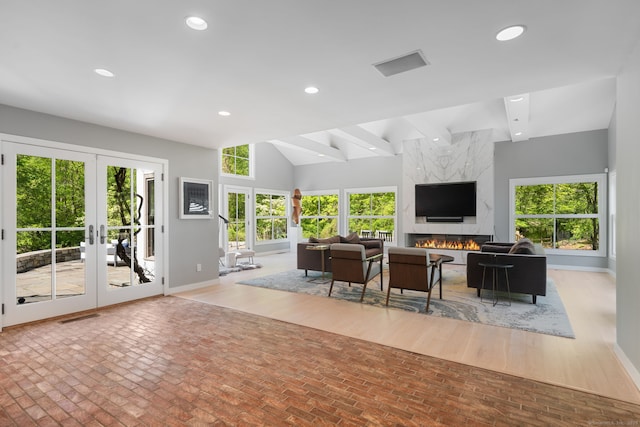 1580 Ponus Rdg, New Canaan, CT 06840 - living room with french doors, brick flooring, recessed lighting, healthy amount of natural light, and lofted ceiling