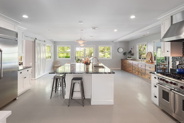 1580 Ponus Rdg, New Canaan, CT 06840 - kitchen with high quality appliances, a sink, dark stone countertops, wall chimney range hood, and white cabinets