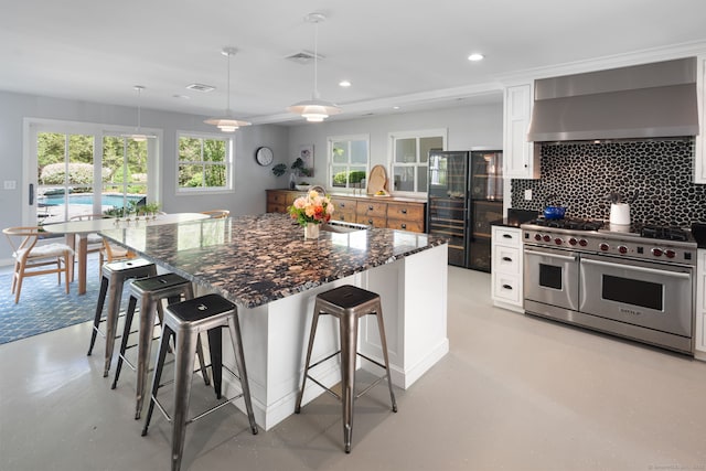 1580 Ponus Rdg, New Canaan, CT 06840 - kitchen with double oven range, wall chimney exhaust hood, tasteful backsplash, a kitchen breakfast bar, and recessed lighting