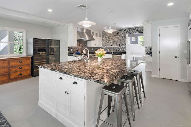 1580 Ponus Rdg, New Canaan, CT 06840 - kitchen featuring wall chimney range hood, beverage cooler, a sink, tasteful backsplash, and finished concrete floors