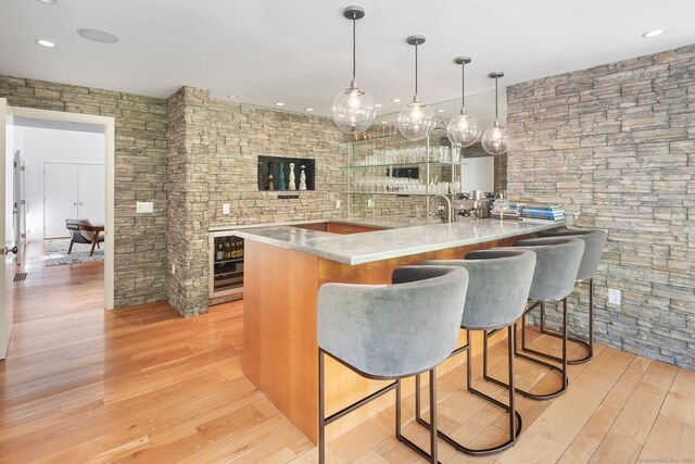 1580 Ponus Rdg, New Canaan, CT 06840 - kitchen with wine cooler, light wood-style floors, a kitchen breakfast bar, pendant lighting, and recessed lighting