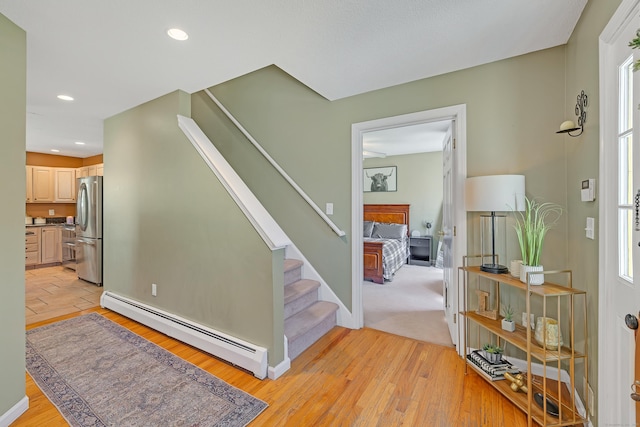 staircase with recessed lighting, baseboards, baseboard heating, and wood finished floors