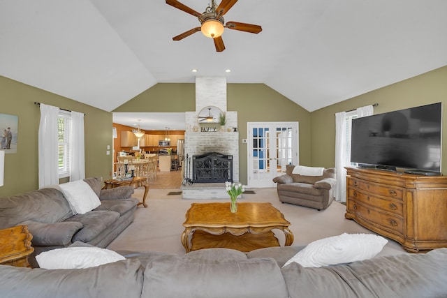 living area with high vaulted ceiling, a fireplace, and a ceiling fan