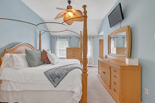 bedroom with ceiling fan, vaulted ceiling, and light carpet