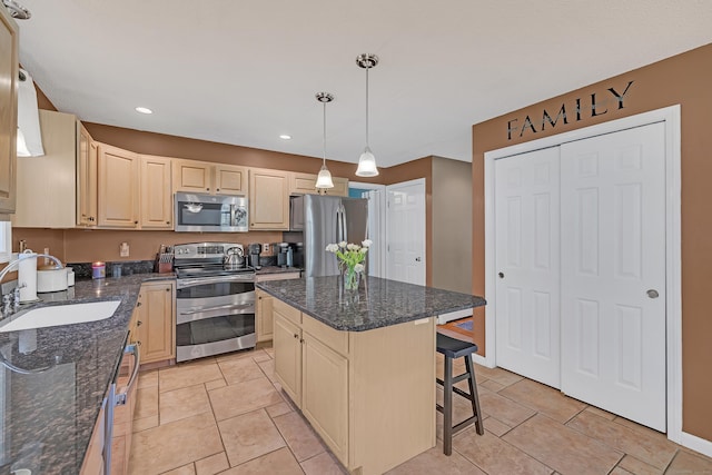 kitchen with a kitchen island, a kitchen bar, recessed lighting, a sink, and stainless steel appliances