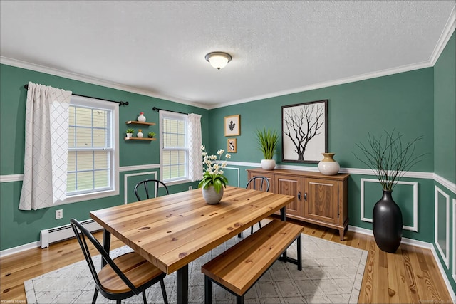 dining space featuring crown molding, wood finished floors, and a wainscoted wall