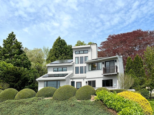 919 Pequot Ave, New London, CT 06320 - view of front of home with a balcony, solar panels, and a chimney