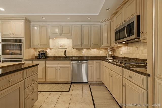 919 Pequot Ave, New London, CT 06320 - kitchen with appliances with stainless steel finishes, decorative backsplash, light tile patterned floors, ornamental molding, and recessed lighting