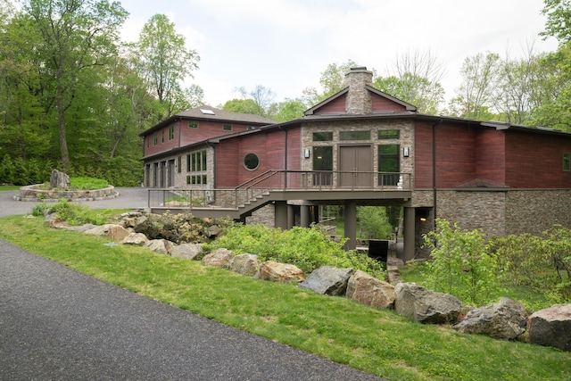 88 Green Ln, Ridgefield, CT 06877 - view of front of property featuring a chimney, a deck, stairs, a garage, and driveway
