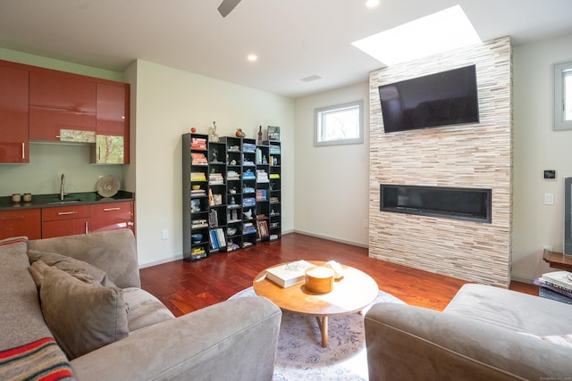 88 Green Ln, Ridgefield, CT 06877 - living area with dark wood finished floors, a tiled fireplace, a skylight, baseboards, and recessed lighting
