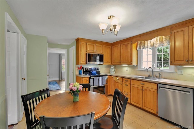 404 Brimfield Rd, Wethersfield, CT 06109 - kitchen featuring stainless steel appliances, a sink, a chandelier, light countertops, and decorative backsplash