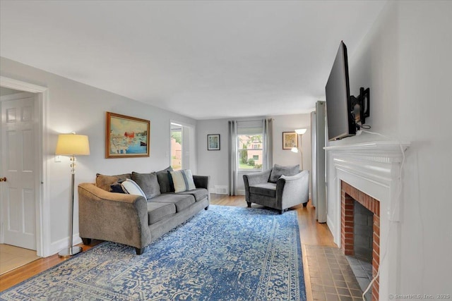 404 Brimfield Rd, Wethersfield, CT 06109 - living area with wood finished floors, a brick fireplace, and baseboards