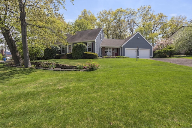 view of front of home with a front yard, driveway, and a garage