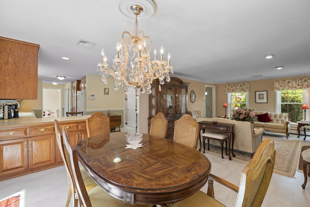 dining room featuring a chandelier, crown molding, visible vents, and recessed lighting