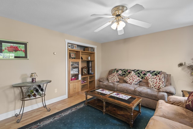 living room with wood finished floors, baseboards, and ceiling fan