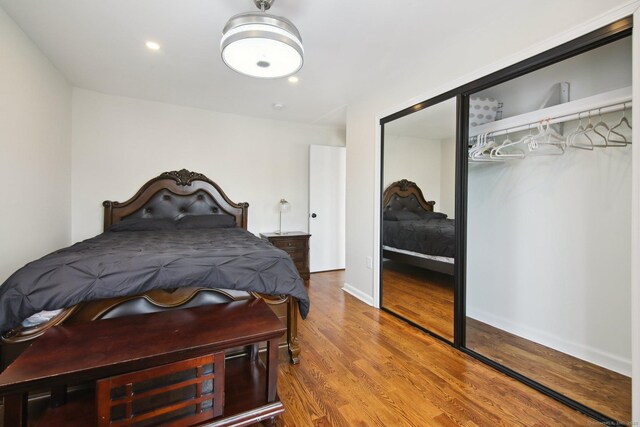 bedroom with wood finished floors, baseboards, a closet, and recessed lighting
