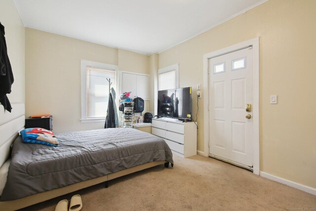 bedroom with light carpet and baseboards
