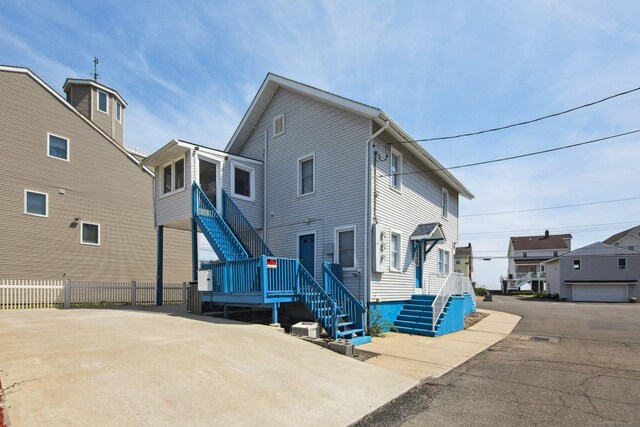 back of house featuring fence and stairs