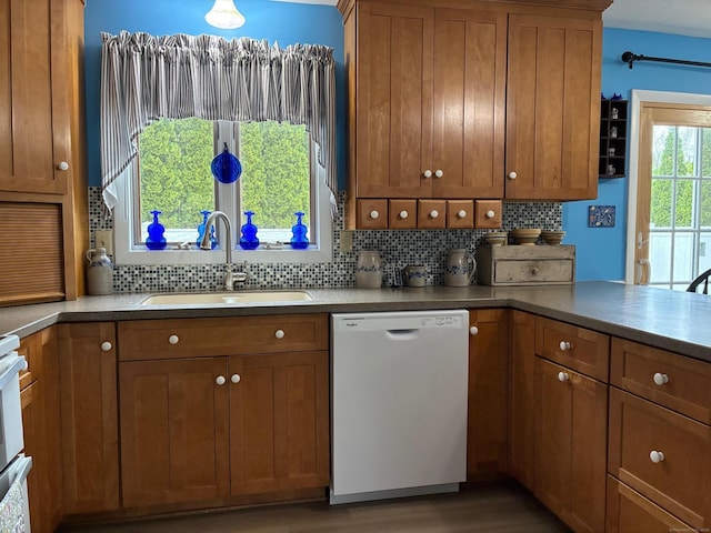 kitchen featuring brown cabinets, a sink, and dishwasher