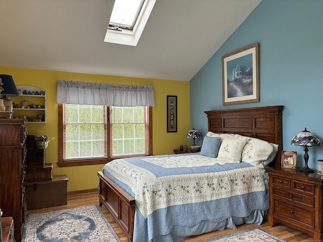 bedroom featuring light wood-style flooring and lofted ceiling with skylight