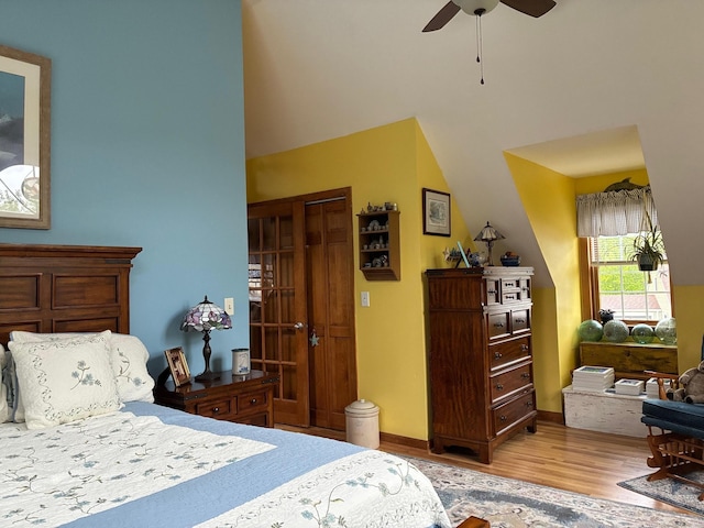 bedroom featuring ceiling fan, a high ceiling, and wood finished floors