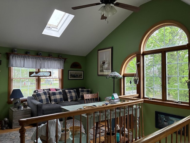 living room with a ceiling fan and lofted ceiling with skylight