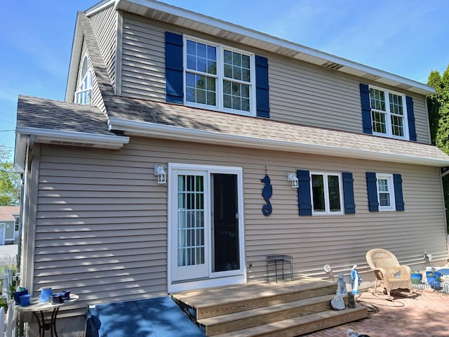 rear view of house with a deck and a shingled roof