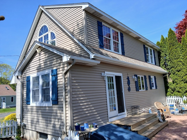 rear view of property featuring a patio area, fence, and a deck