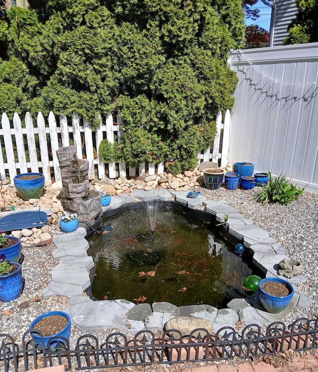 view of yard with a small pond and fence