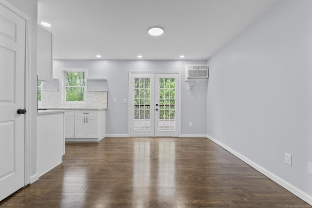 unfurnished dining area featuring dark wood-style flooring, baseboards, a wall mounted AC, and recessed lighting