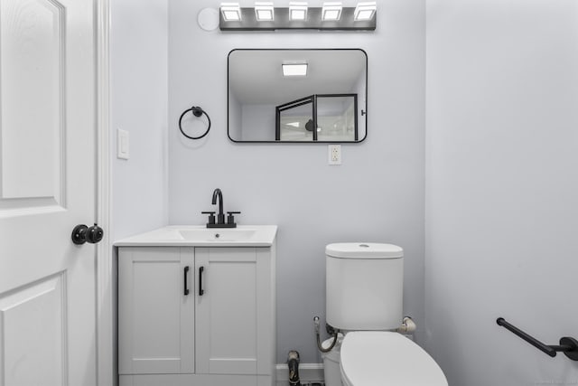 half bath featuring toilet and vanity