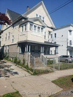 40-42 Hansen Ave, Bridgeport, CT 06605 - view of front of home with a chimney, a porch, and fence private yard