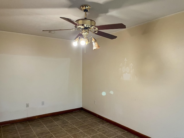 spare room with ceiling fan and baseboards