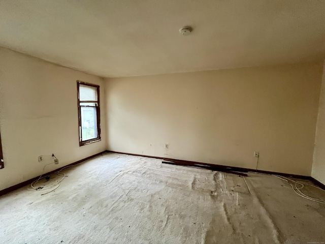 unfurnished room with baseboards