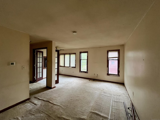 unfurnished room with baseboards, ceiling fan, and carpet