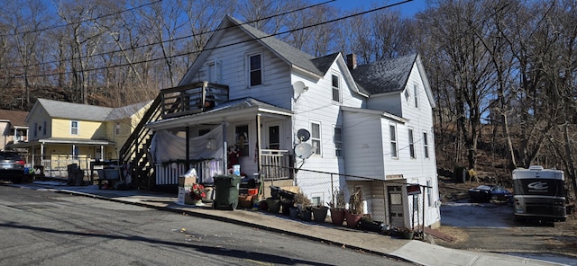 view of front of house featuring a chimney and roof with shingles