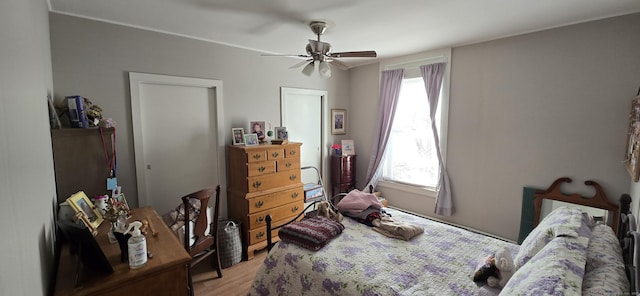 bedroom featuring ceiling fan, ornamental molding, and light wood finished floors