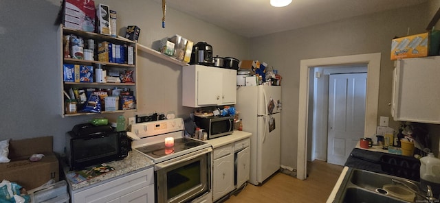 kitchen featuring light countertops, white cabinets, white appliances, and light wood-style flooring