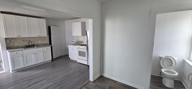 kitchen with white cabinets, dark wood-style flooring, white gas range oven, and decorative backsplash