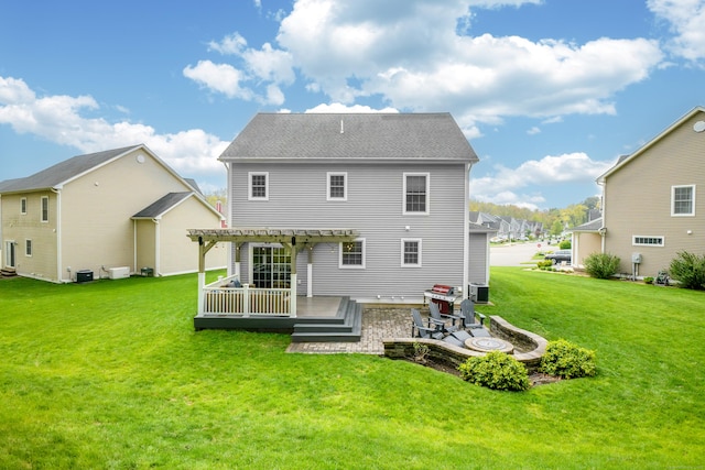 back of property featuring a pergola, a deck, cooling unit, a patio area, and a lawn