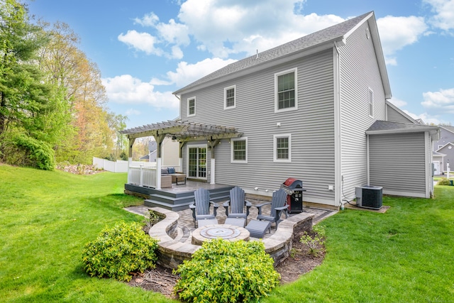 rear view of property with a wooden deck, a pergola, roof with shingles, central AC unit, and a yard