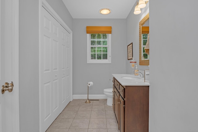 bathroom with toilet, baseboards, tile patterned floors, and vanity