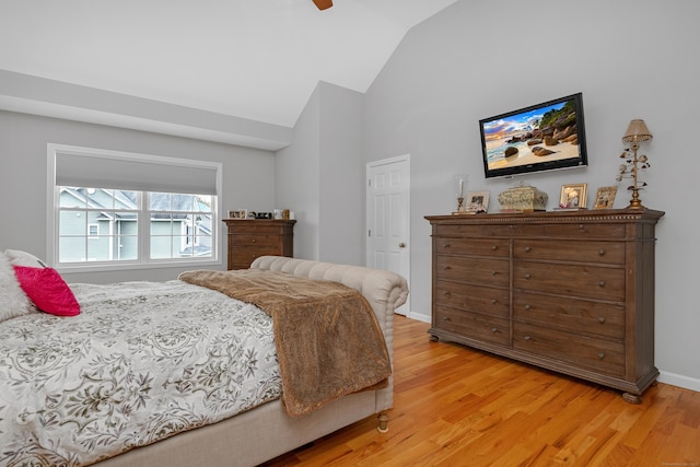 bedroom featuring ceiling fan, light wood-style flooring, and lofted ceiling