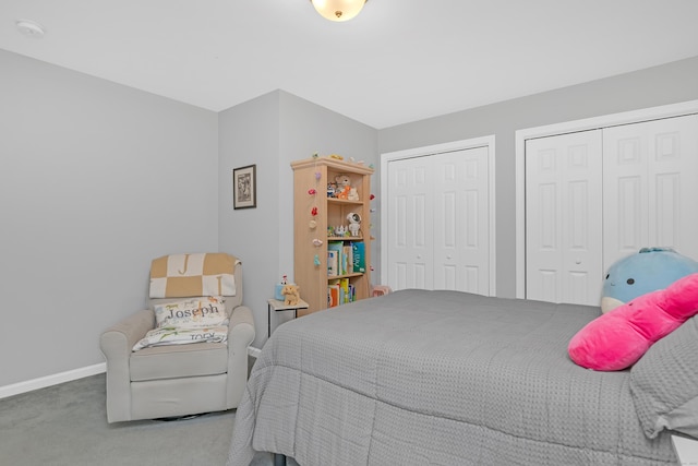 carpeted bedroom with baseboards and multiple closets
