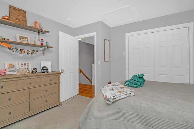 bedroom with a closet, light carpet, and attic access