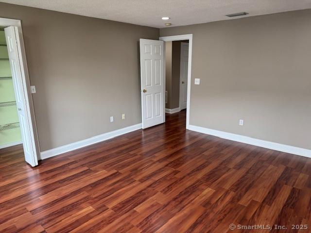 36 Meadowrue Dr Unit 36, Glastonbury, CT 06033 - empty room with baseboards, visible vents, and dark wood-type flooring