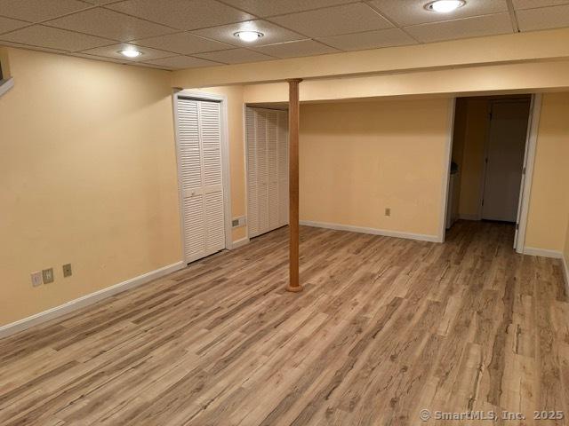 36 Meadowrue Dr Unit 36, Glastonbury, CT 06033 - finished basement with baseboards, a drop ceiling, and wood finished floors